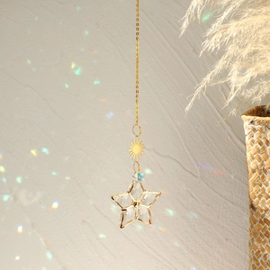Detail of suncatcher showing golden sun metal plate and star-shaped crystal pendant