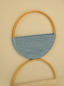 Détail de l'étagère murale bohème tissée main avec cordes en coton bleu et blanc sur bois