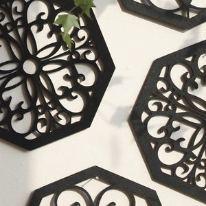Detail of laser-cut black hexagonal mandala wood wall art with intricate hollow design