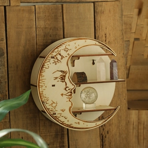 Detail of moon phase wooden wall shelf with intricate lunar face carving and three display tiers