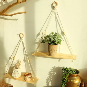 Detail of wooden wall hanging shelf with bohemian woven ropes and decorative beads