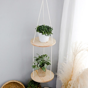 Detail of bohemian handmade 2-tier round wooden hanging shelf with woven cotton rope