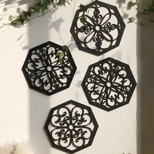 Set of 4 black octagonal wall art panels with symmetrical floral cutout patterns