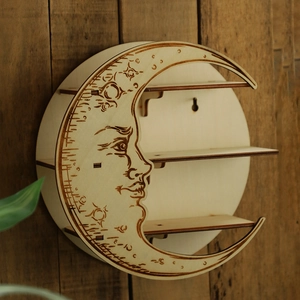 Macro shot of moon shaped wooden wall shelf with triple tiers and celestial carvings