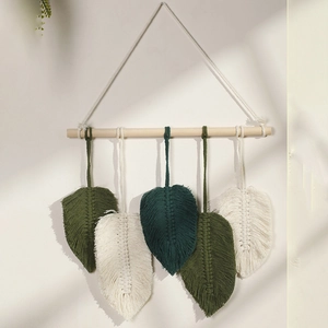 Detail of handmade woven cotton leaf macrame wall hanging with wooden rod decoration