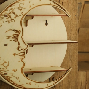 Detail view of crescent moon wooden wall shelf with laser-cut face carving