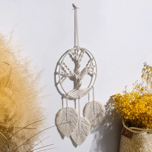 Detail of bohemian handmade wall decor with woven Tree of Life design and leaf tassels