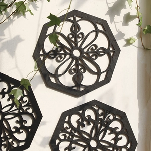 Detailed macro view of geometric black mandala cutout wall art with ivy decor