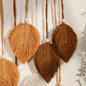 Close-up of macrame leaf wall hanging with cotton rope textures and wooden beads