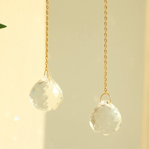 Minimalist crystal suncatcher with golden metal chain and faceted glass pendant