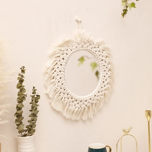 Handwoven boho wall mirror with cotton rope fringe details and an oval acrylic surface