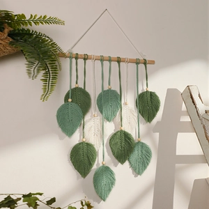 Detail of bohemian leaf tapestry with hand-woven cotton leaves and wooden beads