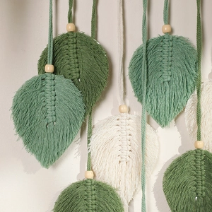 Detail of handcrafted macrame leaf wall hanging with intricate woven texture and wooden beads