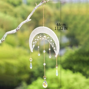Moon-shaped suncatcher with woven cotton rope and crystals hanging from a tree branch