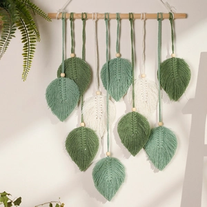 Detail of bohemian handmade woven leaf wall hanging with cotton cords and wooden beads