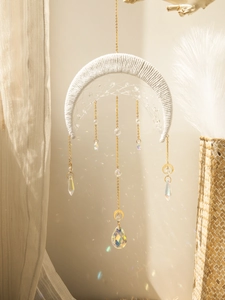 Detail of bohemian crescent moon suncatcher with crystal prisms and golden chains