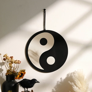 Artistic wall decor showing a round Yin Yang acrylic mirror hanging on a textured wall