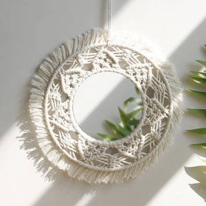 Detail of bohemian handmade cotton woven mirror with fringe and macrame flower pattern