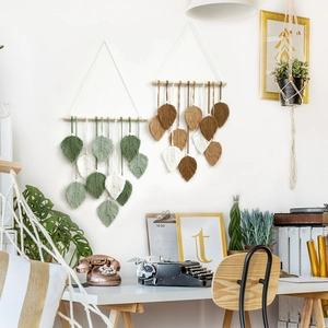 Bohemian macrame wall hanging with handmade cotton leaves on a natural wooden branch