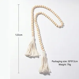 Detail view of handmade wooden bead curtain tieback with cotton tassels for bohemian decor