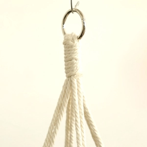 Close-up of handmade bohemian woven cotton rope knots with a silver metal hanging ring