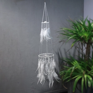 Macro detail of multi-layer white dream catcher with hanging feathers and white beads