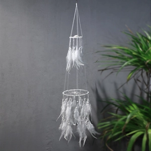 Macro detail of bohemian dream catcher with white feathers and elegant round beads