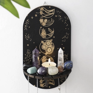 Detail of black wooden altar shelf with gold celestial engravings and crystal display