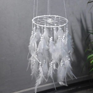 Close-up of pure white dream catcher with soft feathers and a large center pearl detail