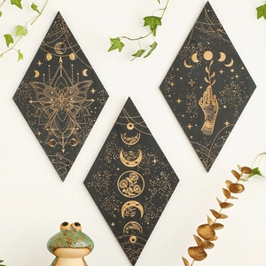 Close-up of three diamond-shaped black wall plaques with gold celestial butterfly patterns