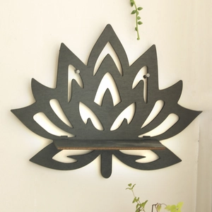 Detail of black lotus wooden wall shelf with laser-cut hollow design for crystals
