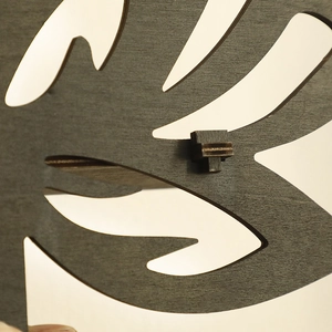 Minimalist flower-shaped hollow wooden shelf with dark charcoal wood grain texture