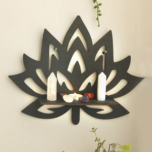 Detail of black lotus wooden shelf holding crystal pillars and candles in a zen setting