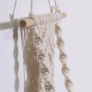 Detailed close-up of Bohemian macrame wall hanging with intricate cotton rope weaving texture