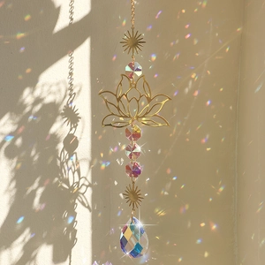 Golden lotus sun catcher with crystal prisms casting rainbow light on a wall