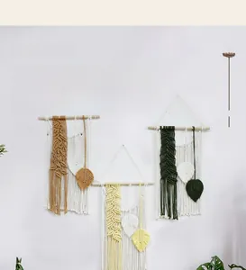 Detail of bohemian hand-woven wall hanging with cotton tassel leaves in earthy tones