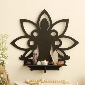 Detail of black lotus flower crystal shelf with wooden yoga silhouette and small candles