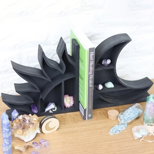 Detail of matte black sun and moon wooden wall shelves used for crystal storage and decor