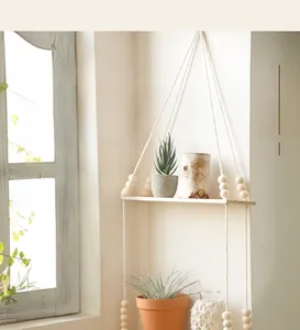 Close-up of bohemian hanging shelf with handwoven cotton ropes and natural wood beads