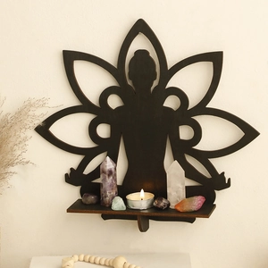 Detail of meditation figure and lotus wood shelf holding crystals and tea light candle