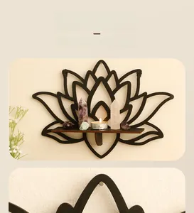 Detail of bohemian black wooden lotus wall shelf holding crystals and tea light candle