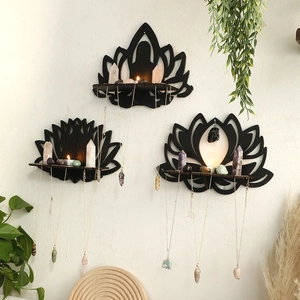 Detail of black lotus wooden wall shelves displaying crystals and hanging necklaces
