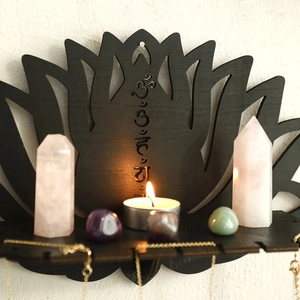 Close-up of black lotus wooden wall shelf with spiritual engraving and crystal display