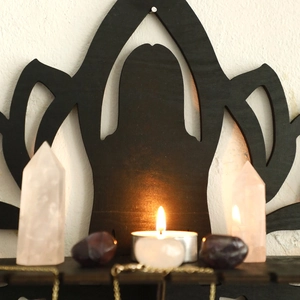 Detail of lotus flower wooden wall shelf with pink crystal pillars and tea light candle