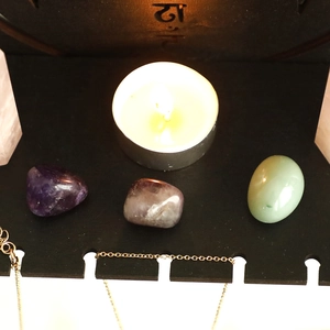 Macro detail of polished amethyst, aventurine stones and gold necklace on display