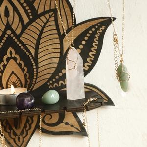 Floral wooden shelf with healing crystal necklaces and stones for spiritual home decor