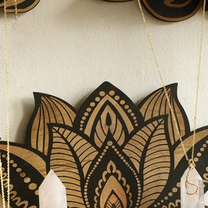 Pink quartz pendant necklace with gold wire wrap on wooden lotus wall shelf decor