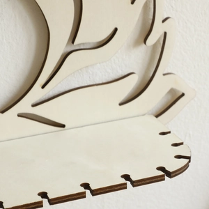Laser-cut wooden lotus wall shelf with earring hanging slots in natural wood finish