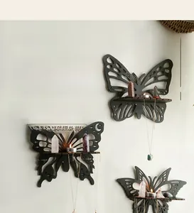 Detailed view of butterfly wall shelf holding crystals and candles on a textured wall