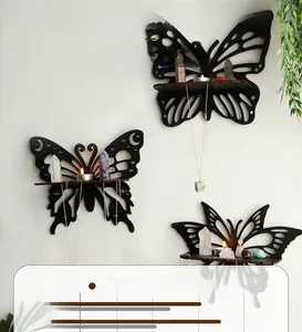 Detail of three black butterfly-shaped wall shelves with carved hollow wood texture